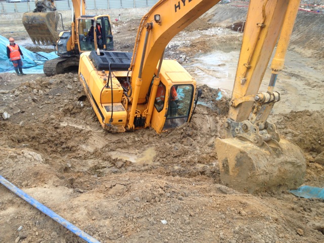 Construction machine bogged down in liquefied soil